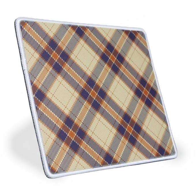 Zijaanzicht - gekanteld naar rechts - van een stoffen muismat met een witte gestikte rand met een diagonaal ruitpatroon (plaid / tartan) in cremé, marineblauw en oranje kleuren, met kruisende strepen en ruitvormen.